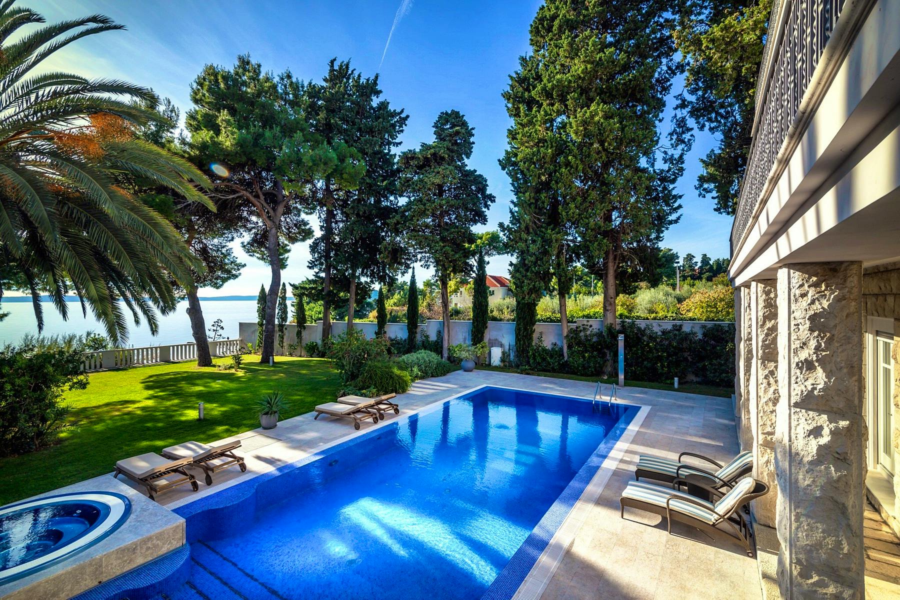 Large swimming pool with sunbathing area right by the sea