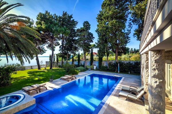 Large swimming pool with sunbathing area right by the sea