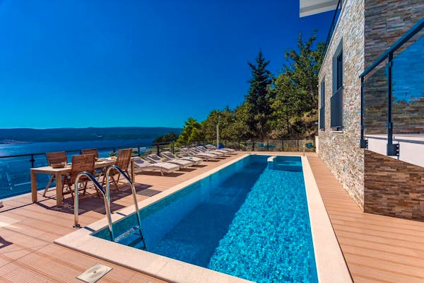 Spacious swimming pool and sundeck overlooking the sea