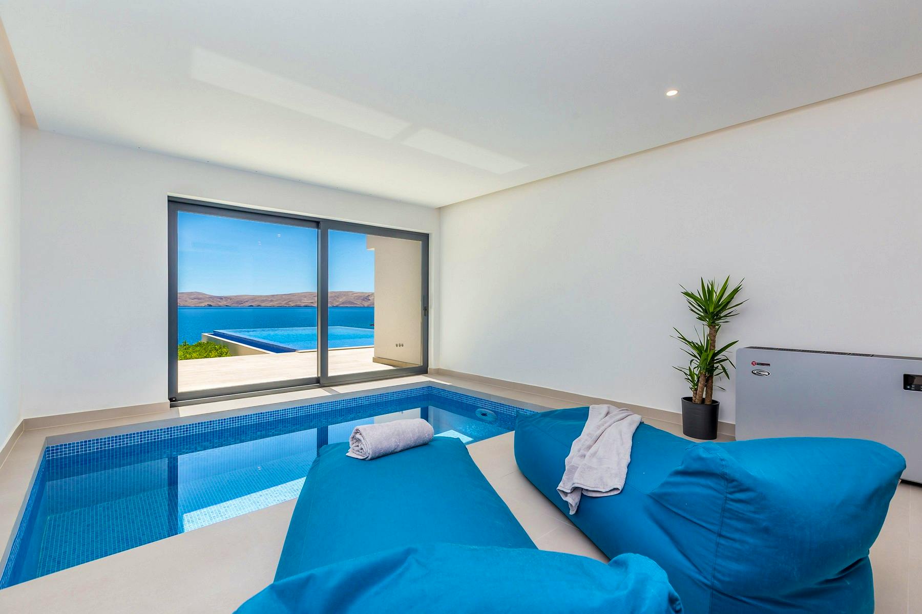Unutarnji bazen s lounge zonom i pogledom na more