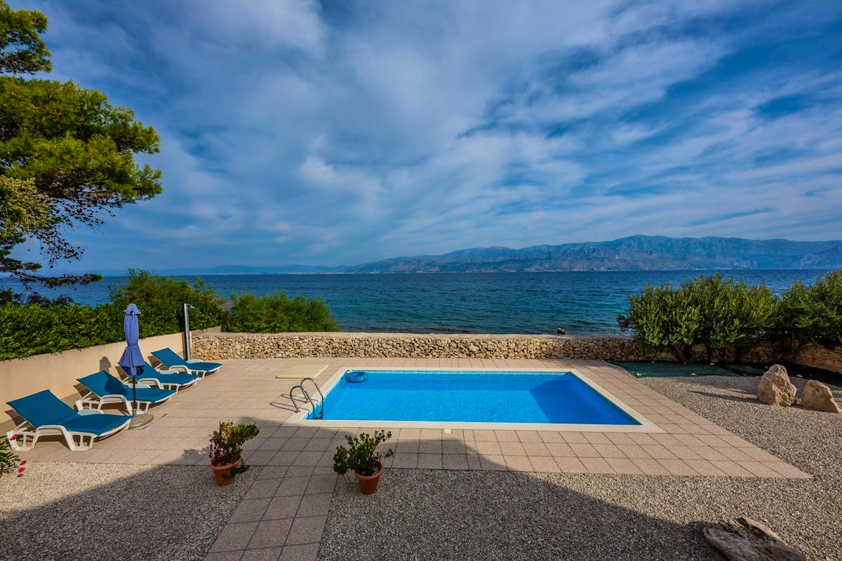 View of the pool with sundeck and the sea