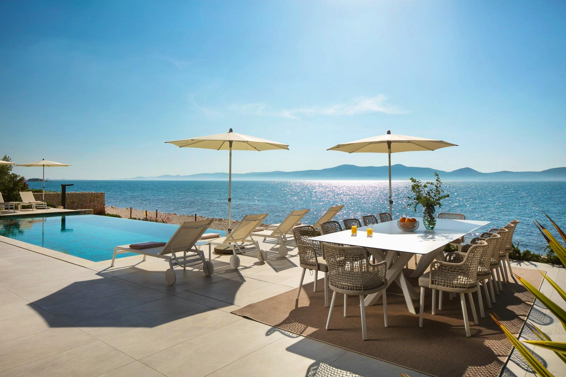 Spacious terrace with infinity pool and sundeck overlooking the sea