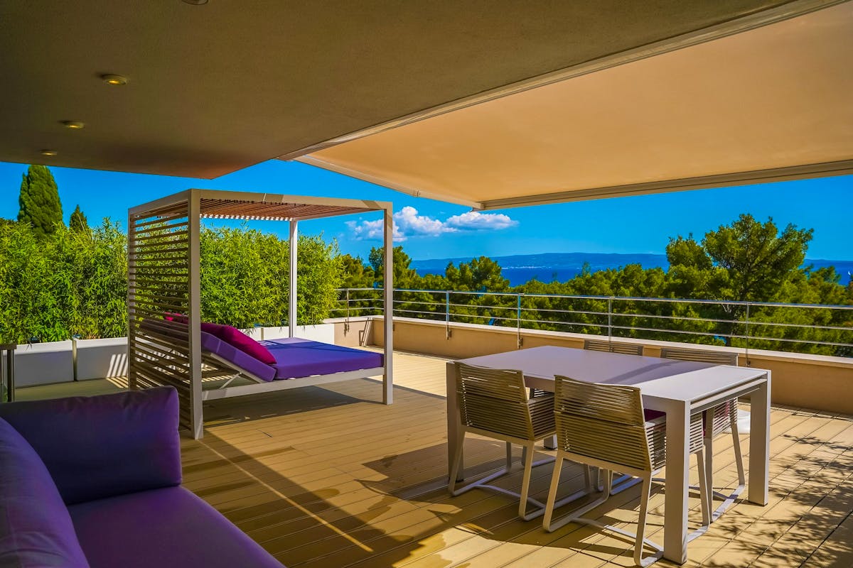 Spacious terrace with lounge and dining area overlooking the sea